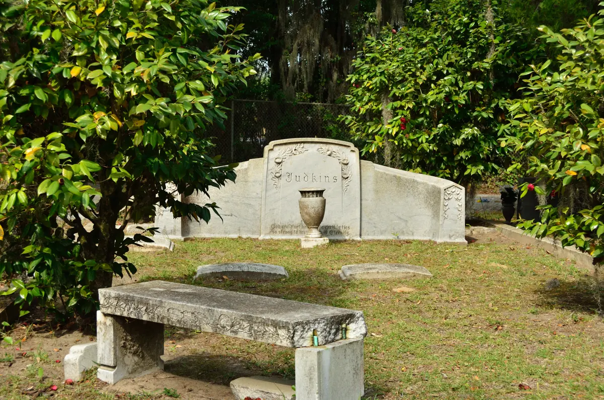 A stone bench and family monument in Bonaventure Cemetery on a Savannah GA cemetery tour